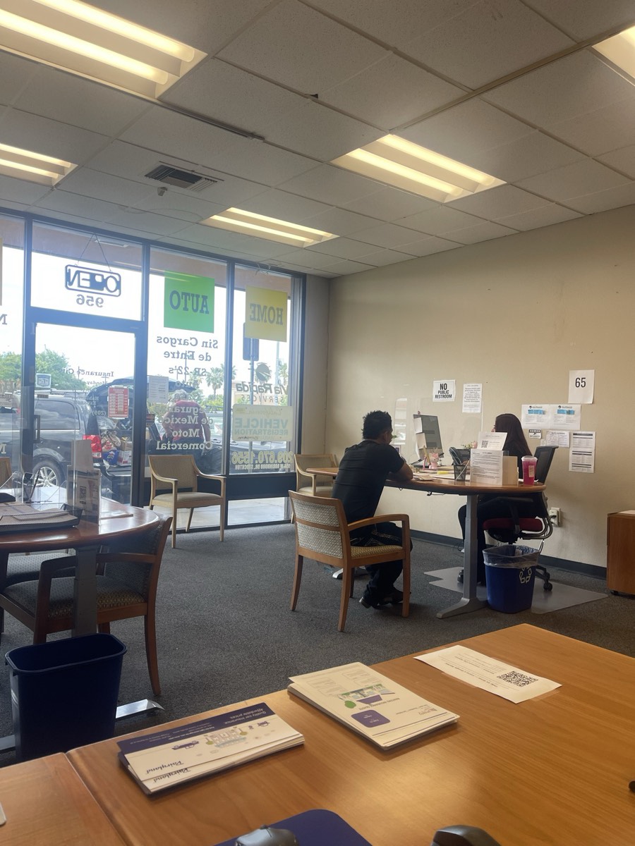 Bilingual agent writing same-day Mexico travel insurance for a customer at Via Rapida Services
