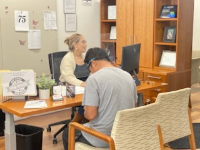 Bilingual Via Rapida agent helping a customer at the San Jose office